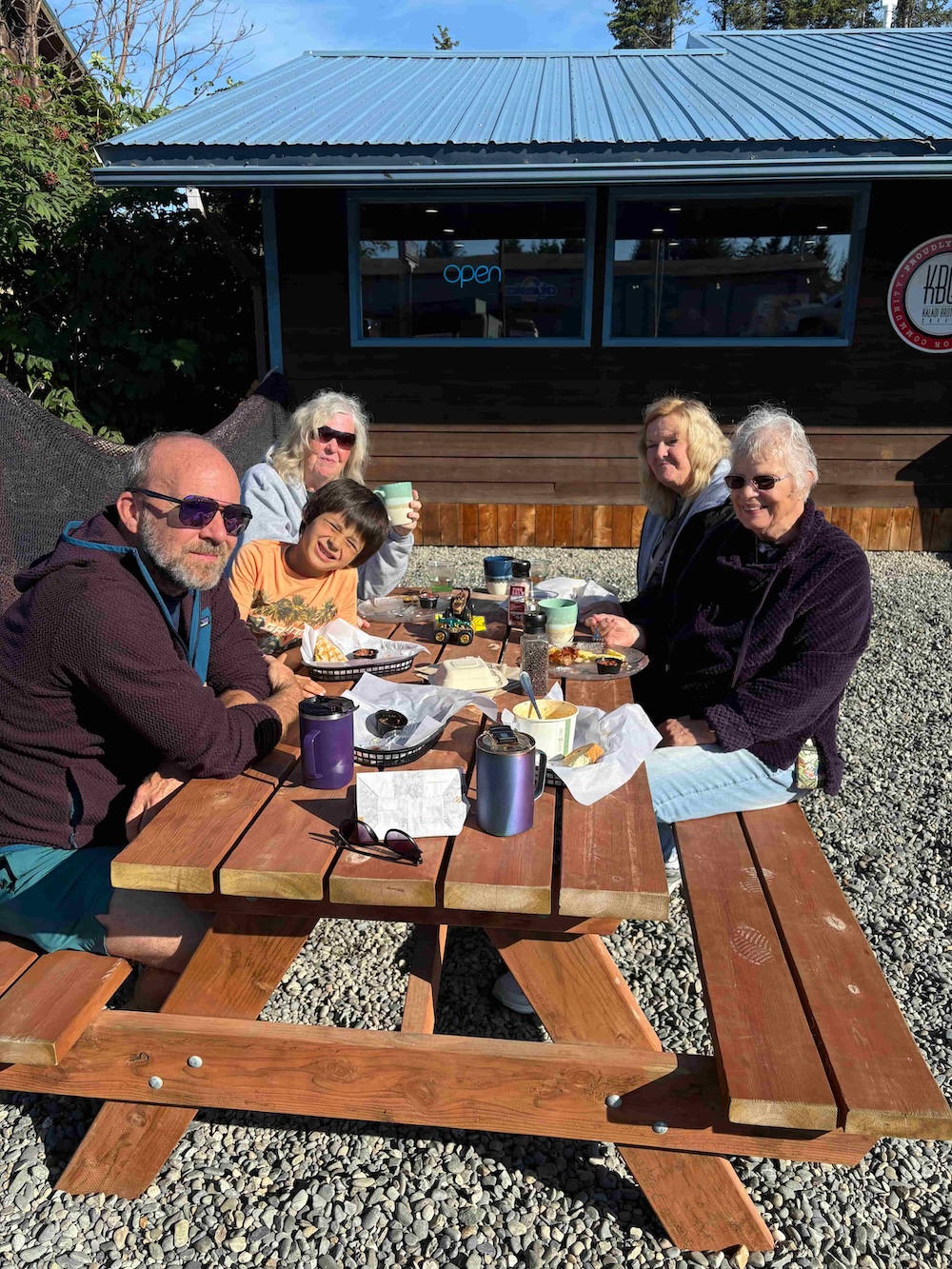 Family enjoying a meal together outdoors in Homer, Alaska