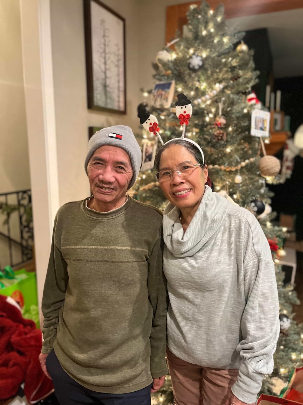 Couple smiling together by the Christmas tree